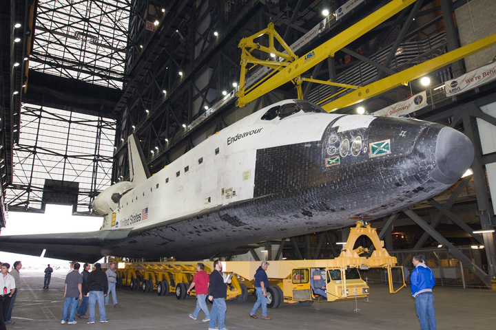 Image of a space shuttle orbiter in a horizontal position in a large assembly building.