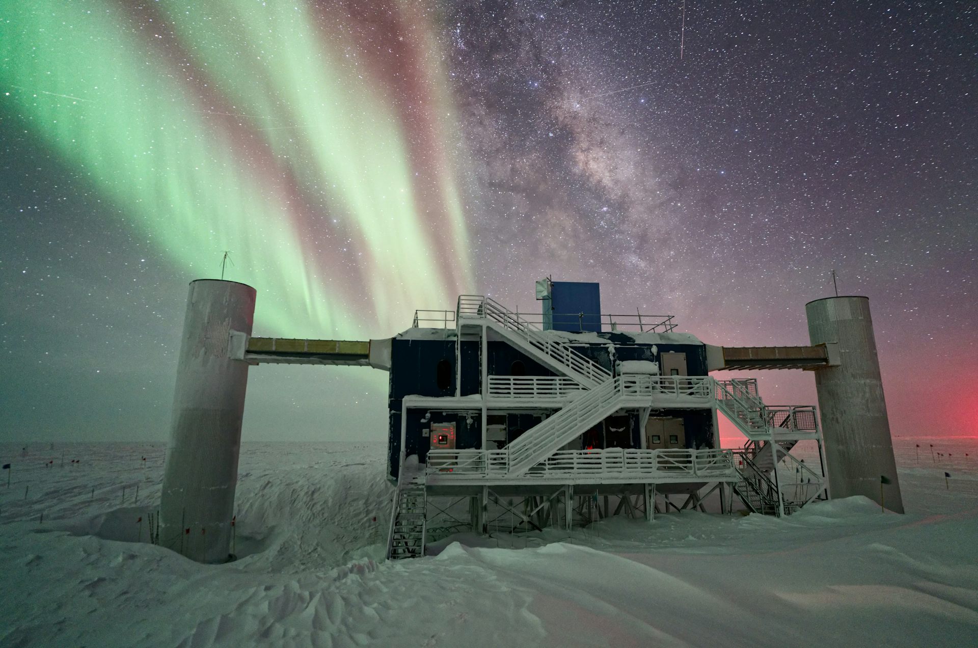 building on snowy ground with aurorae in the night sky