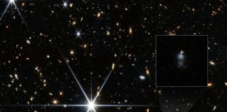 Astronomers pinpoint the origin of a 10 billion-year-old millisecond signal from space Picture taken by the JWST on the patch of sky where the FRB originated from. An inset shows a zoomed in view of the host galaxy with a white cross marking the location of the radio signal.