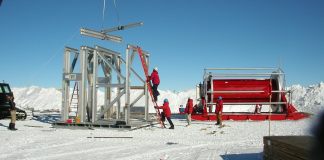 I’m a physicist who worked on the Nobel-winning neutrino search – here’s how a cubic kilometer of Antarctic ice became a telescope for ghost particles from space Bundled up construction workers with metal beams on snowy landscape.